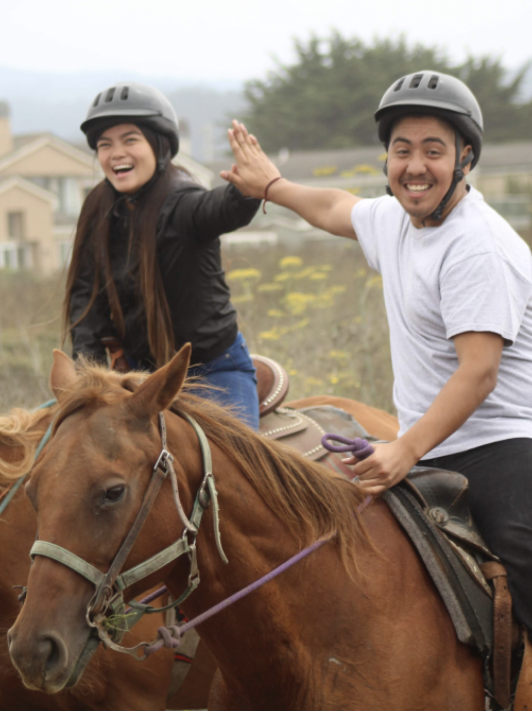 FLY youth and mentor high-fiving on horseback